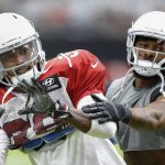 Arizona Cardinals defensive back Tre Boston, left, works with defensive back Antoine Bethea, right, on catching drills during an NFL football practice Saturday, Aug. 4, 2018, in Glendale, Ariz. (AP Photo/Ross D. Franklin)