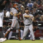 San Francisco Giants relief pitcher Sam Dyson, right, throws to first base for the out on Arizona Diamondbacks' Ketel Marte as catcher Nick Hundley, middle, watches during the eighth inning of a baseball game Friday, Aug. 3, 2018, in Phoenix. The Diamondbacks won 6-3. (AP Photo/Ross D. Franklin)