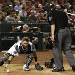Arizona Diamondbacks catcher Jeff Mathis, left, reaches for a pitch that gets away as he avoids umpire Manny Gonzalez during the third inning of a baseball game against the Los Angeles Angels, Tuesday, Aug. 21, 2018, in Phoenix. (AP Photo/Ross D. Franklin)