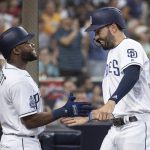 San Diego Padres' Manuel Margot, left, welcomes Eric Hosmer after Hosmer scored on an RBI-single by Austin Hedges during the fifth inning of a baseball game against the Arizona Diamondbacks in San Diego, Saturday, Aug. 18, 2018. (AP Photo/Kyusung Gong)