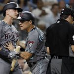 Arizona Diamondbacks' Nick Ahmed, left, is held back by third base coach Tony Perezchica, center, as he argues with umpire James Hoye, right, during the third inning of the team's baseball game against the San Diego Padres on Friday, Aug. 17, 2018, in San Diego. (AP Photo/Gregory Bull)