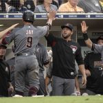 Arizona Diamondbacks' Jon Jay (9) is welcomed in the dugout after scoring on a sacrifice fly by A.J. Pollock during the fifth inning of a baseball game against the San Diego Padres in San Diego, Saturday, Aug. 18, 2018. (AP Photo/Kyusung Gong)