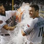 After putting down a sacrifice bunt in the ninth inning, Arizona Diamondbacks' A.J. Pollock (11) gets doused with water by teammate Steven Souza Jr., left, after a baseball game against the Los Angeles Angels, Tuesday, Aug. 21, 2018, in Phoenix. The Diamondbacks defeated the Angels 5-4. (AP Photo/Ross D. Franklin)