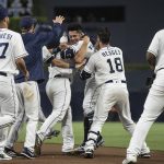 San Diego Padres celebrate after Christian Villanueva, center right, hit a walk-off single against the Arizona Diamondbacks during a baseball game in San Diego, Saturday, Aug. 18, 2018. The Padres won 7-6. (AP Photo/Kyusung Gong)