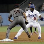 Los Angeles Dodgers' Yasiel Puig (66) is tagged out by Arizona Diamondbacks starting pitcher Robbie Ray as Puig tried to advance to second base following a throwing error on his ground ball during the second inning of a baseball game Thursday, Aug. 30, 2018, in Los Angeles. (AP Photo/Marcio Jose Sanchez)