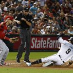 A wild throw by Los Angeles Angels relief pitcher Cam Bedrosian gets past Angels third baseman Taylor Ward, left, as Arizona Diamondbacks center fielder Jon Jay (9) slides safely into third base as umpire Andy Fletcher, middle, looks on during the ninth inning of a baseball game, Tuesday, Aug. 21, 2018, in Phoenix. The Diamondbacks defeated the Angels 5-4. (AP Photo/Ross D. Franklin)