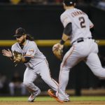 San Francisco Giants shortstop Brandon Crawford, left, fields a grounder hit by Arizona Diamondbacks' Ketel Marte, starting a double play, as second baseman Chase d'Arnaud (2) watches during the seventh inning of a baseball game Friday, Aug. 3, 2018, in Phoenix. The Diamondbacks won  6-3. (AP Photo/Ross D. Franklin)