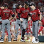 Arizona Diamondbacks relief pitcher Archie Bradley, center, is relieved by manager Torey Lovullo (17) in the eighth inning of a baseball game against the Cincinnati Reds, Saturday, Aug. 11, 2018, in Cincinnati. (AP Photo/John Minchillo)