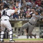 Arizona Diamondbacks' Eduardo Escobar, right, slides towards home plate as San Diego Padres catcher Austin Hedges looks on during the fifth inning of a baseball game in San Diego, Saturday, Aug. 18, 2018. (AP Photo/Kyusung Gong)