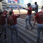 Arizona Diamondbacks center fielder A.J. Pollock, top, is congratulated in the dugout after hitting a home run during the ninth inning of a baseball game against the San Diego Padres, Sunday, Aug. 19, 2018, in San Diego. (AP Photo/Orlando Ramirez)