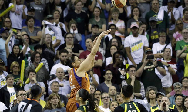 Subdued Seattle Storm fans look on as Phoenix Mercury's Diana Taurasi nails a 3-point shot with sec...