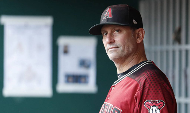 Arizona Diamondbacks manager Torey Lovullo works in the dugout before a baseball game against the C...