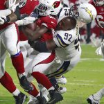 Los Angeles Chargers defensive tackle Brandon Mebane (92) loses his helmet as he tackles Arizona Cardinals running back Chase Edmonds (29) during the first half of a preseason NFL football game, Saturday, Aug. 11, 2018, in Glendale, Ariz. (AP Photo/Rick Scuteri)