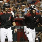 Arizona Diamondbacks' Daniel Descalso, left, and Ketel Marte, right, celebrate after scoring against the San Francisco Giants on a single by pitcher Patrick Corbin during the first inning of a baseball game Friday, Aug. 3, 2018, in Phoenix. (AP Photo/Ross D. Franklin)
