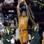 Phoenix Mercury's Brittney Griner (42) leaps to get off a pass between Seattle Storm's Jewell Loyd (24) and Natasha Howard in the first half in a WNBA basketball playoff semifinal Tuesday, Aug. 28, 2018, in Seattle. (AP Photo/Elaine Thompson)