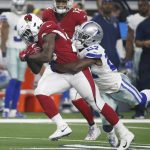 Arizona Cardinals running back Chase Edmonds, left, is wrapped up by Dallas Cowboys cornerback Jourdan Lewis (27) after a long run during the first half of a preseason NFL football game in Arlington, Texas, Sunday, Aug. 26, 2018. (AP Photo/Michael Ainsworth)
