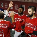 Los Angeles Angels' David Fletcher (6) celebrates his run scored against the Arizona Diamondbacks with Kaleb Cowart, right, and Eric Young Jr., middle, during the third inning of a baseball game Tuesday, Aug. 21, 2018, in Phoenix. (AP Photo/Ross D. Franklin)