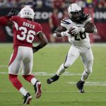 Los Angeles Chargers running back Melvin Gordon (28) makes a catch as Arizona Cardinals defensive back Budda Baker (36) defends during the first half of a preseason NFL football game, Saturday, Aug. 11, 2018, in Glendale, Ariz. (AP Photo/Rick Scuteri)