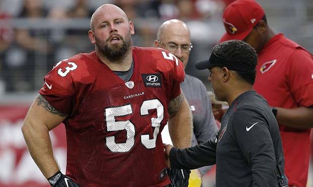 An injured Arizona Cardinals center A.Q. Shipley (53) is checked by head athletic trainer Tom Reed,...