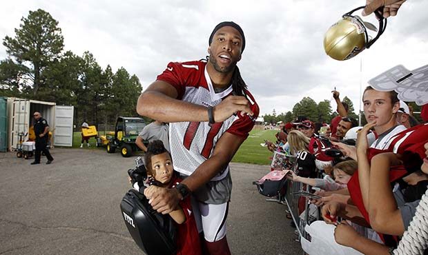 Arizona Cardinals' Larry Fitzgerald, with son Devin Fitzgerald on the Segway, signs autographs afte...