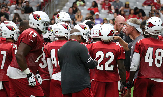 The Cardinals huddle around offensive coordinator Mike McCoy on Saturday, July 28, 2018, the first ...