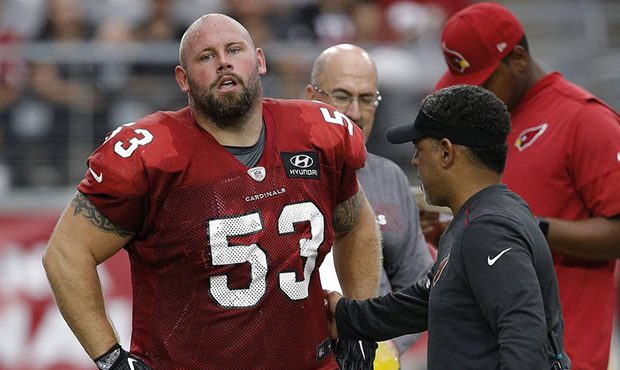 An injured Arizona Cardinals center A.Q. Shipley (53) is checked by head athletic trainer Tom Reed,...