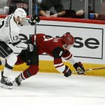Los Angeles Kings left wing Kyle Clifford (13) sends Arizona Coyotes center Clayton Keller (9) to the ice during the third period of an NHL preseason hockey game Tuesday, Sept. 18, 2018, in Glendale, Ariz. (AP Photo/Ross D. Franklin)