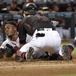 Atlanta Braves' Ozzie Albies is tagged out by Arizona Diamondbacks' Jeff Mathis (2) as he tries to score on a fielders choice hit into by Dansby Swanson during the second inning of a baseball game, Saturday, Sept. 8, 2018, in Phoenix. (AP Photo/Matt York)