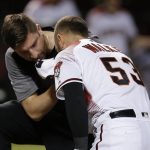 Arizona Diamondbacks' Christian Walker (53) is attended to by head athletic trainer Bryan DiPanfilo, left, after Walker was hit in the face by a pitch during the eighth inning of a baseball game against the Los Angeles Dodgers, Monday, Sept. 24, 2018, in Phoenix. The Dodgers defeated the Diamondbacks 7-4. (AP Photo/Ross D. Franklin)