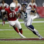 Seattle Seahawks quarterback Russell Wilson (3) scrambles as Arizona Cardinals defensive end Benson Mayowa (91) pursues during the first half of an NFL football game, Sunday, Sept. 30, 2018, in Glendale, Ariz. (AP Photo/Ross D. Franklin)