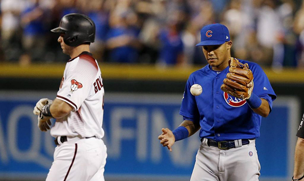 Chicago Cubs shortstop Addison Russell, right, flips the ball in the air after tagging out Arizona ...
