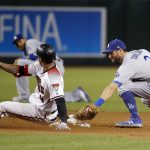 Arizona Diamondbacks' Ketel Marte (4) slides safely into second base ahead of the tag by Los Angeles Dodgers second baseman Chris Taylor (3), after a fielding error by Dodgers center fielder Cody Bellinger, during the sixth inning of a baseball game Wednesday, Sept. 26, 2018, in Phoenix. (AP Photo/Ross D. Franklin)