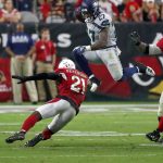 Seattle Seahawks running back Mike Davis (27) leaps over Arizona Cardinals defensive back Patrick Peterson (21) during the second half of an NFL football game, Sunday, Sept. 30, 2018, in Glendale, Ariz. (AP Photo/Rick Scuteri)