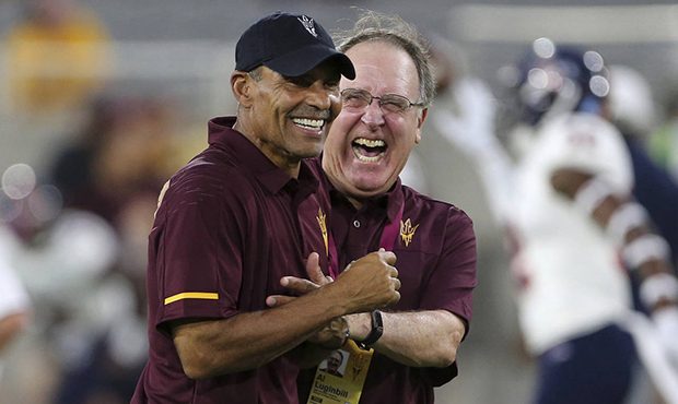 Arizona State head coach Herm Edwards, left, laughs with some team personnel prior to an NCAA colle...