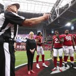 Cindy McCain, wife of the late U.S. Sen. John McCain, R-Ariz., stands with Arizona Cardinals' Larry Fitzgerald (11), Patrick Peterson (21), Corey Peters (98) and Chandler Jones (55) as an honorary team captain as referee Walt Coleman tosses the coin prior to an NFL football game against the Washington Redskins , Sunday, Sept. 9, 2018, in Glendale, Ariz. (AP Photo/Rob Schumacher, Pool)