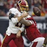 Washington Redskins quarterback Alex Smith (11) gets a pass off as he is hit by Arizona Cardinals defensive tackle Robert Nkemdiche during the second half of an NFL football game, Sunday, Sept. 9, 2018, in Glendale, Ariz. (AP Photo/Ross D. Franklin)