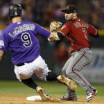 Arizona Diamondbacks third baseman Daniel Descalso, back, forces out Colorado Rockies' DJ LeMahieu at second base on the front end of a double play hit into by Nolan Armando to end the seventh inning of a baseball game Wednesday, Sept. 12, 2018, in Denver. (AP Photo/David Zalubowski)
