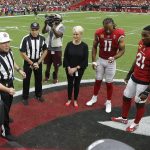 Cindy McCain, wife of the late U.S. Sen. John McCain, R-Ariz., stands with Arizona Cardinals players' Larry Fitzgerald (11) and Patrick Peterson (21) as an honorary team captain during the coin toss prior to an NFL football game against the Washington Redskins, Sunday, Sept. 9, 2018, in Glendale, Ariz. (AP Photo/Ross D. Franklin, Pool)
