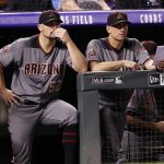 Arizona Diamondbacks starting pitcher Zach Godley, left, looks on with manager Torey Lovullo from the dugout as the Diamondbacks bat against the Colorado Rockies in the sixth inning of a baseball game Monday, Sept. 10, 2018, in Denver. (AP Photo/David Zalubowski)
