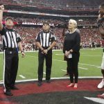 Cindy McCain, wife of the late U.S. Sen. John McCain, R-Ariz., stands with Arizona Cardinals and Washington Redskins players as an honorary team captain during the coin toss by referee Walt Coleman, left, prior to an NFL football game , Sunday, Sept. 9, 2018, in Glendale, Ariz. (AP Photo/Ross D. Franklin, Pool)