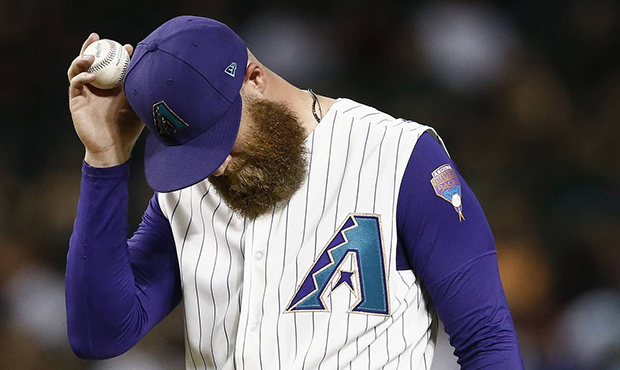Arizona Diamondbacks relief pitcher Archie Bradley pauses on the mound after giving up a ball to al...
