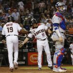 Arizona Diamondbacks' Socrates Brito (19) celebrates his home run with A.J. Pollock (11) as Los Angeles Dodgers catcher Yasmani Grandal, right, pauses at home plate during the second inning of a baseball game Wednesday, Sept. 26, 2018, in Phoenix. (AP Photo/Ross D. Franklin)