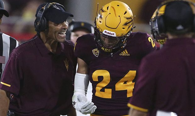 Arizona State head coach Herm Edwards, left, talks to defensive back Chase Lucas (24) during the fi...