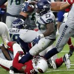 Seattle Seahawks running back Mike Davis (27) scores a touchdown as Arizona Cardinals defensive back Bene' Benwikere (23) defends during the second half of an NFL football game, Sunday, Sept. 30, 2018, in Glendale, Ariz. (AP Photo/Rick Scuteri)