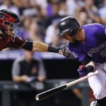 Colorado Rockies' Trevor Story, right, tries to avoid the tag by Arizona Diamondbacks catcher Alex Avila after a dropped third strike in the third inning of a baseball game Wednesday, Sept. 12, 2018, in Denver. (AP Photo/David Zalubowski)