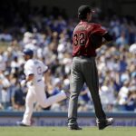 Arizona Diamondbacks starting pitcher Clay Buchholz, right, steps off the mound after giving up a solo home run to Los Angeles Dodgers' Max Muncy, left, during the fifth inning of a baseball game Sunday, Sept. 2, 2018, in Los Angeles. (AP Photo/Marcio Jose Sanchez)