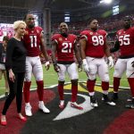 Cindy McCain, wife of the late U.S. Sen. John McCain, R-Ariz., embraces Arizona Cardinals' Larry Fitzgerald (11), Patrick Peterson (21), Corey Peters (98) and Chandler Jones (55) as an honorary team captain during the coin toss prior to an NFL football game against the Washington Redskins , Sunday, Sept. 9, 2018, in Glendale, Ariz. (AP Photo/Rob Schumacher, Pool)
