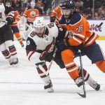 Arizona Coyotes ' Jason Demers (55) and Edmonton Oilers' Tobias Rieder (22) compete for the puck during the second period of an NHL hockey preseason game Thursday, Sept. 27, 2018, in Edmonton, Alberta. (Jason Franson/The Canadian Press via AP)
