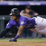 Colorado Rockies' Ian Desmond dives into home plate to score on a single hit by Tony Wolters against Arizona Diamondbacks starting pitcher Zack Godley in the fifth inning of a baseball game Monday, Sept. 10, 2018, in Denver. (AP Photo/David Zalubowski)