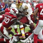 Washington Redskins running back Adrian Peterson (26) scores a touchdown as Arizona Cardinals linebacker Deone Bucannon (20) defends during the first half of an NFL football game, Sunday, Sept. 9, 2018, in Glendale, Ariz. (AP Photo/Rick Scuteri)